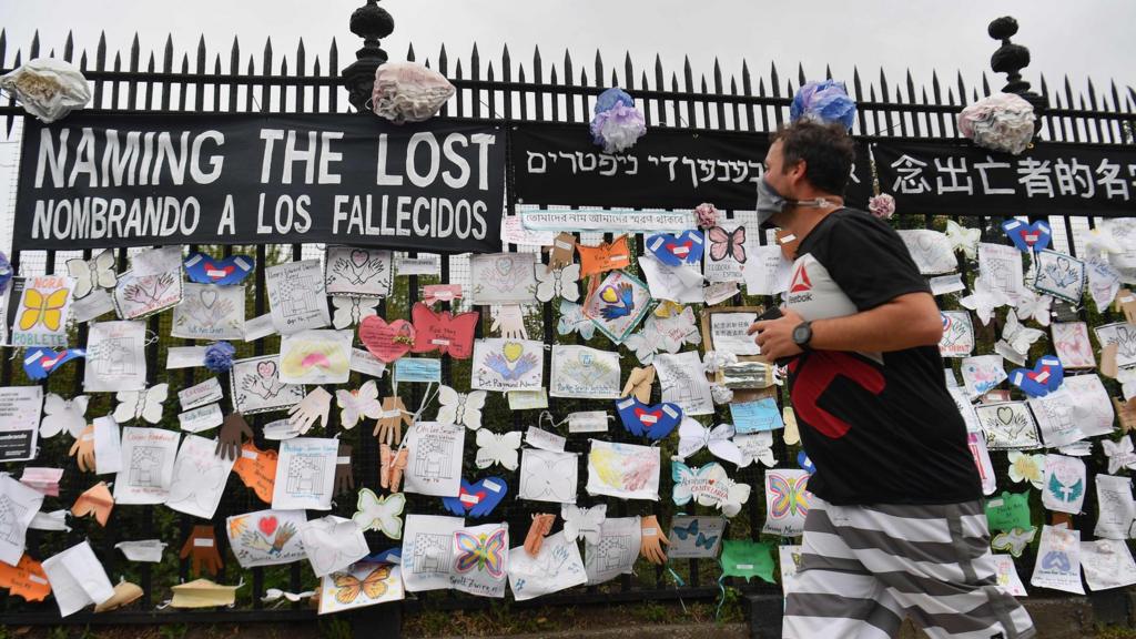 A woman walks past a memorial for Covid-19 victims at Greenwood Cemetery in New York City on 28 May 28, 2020