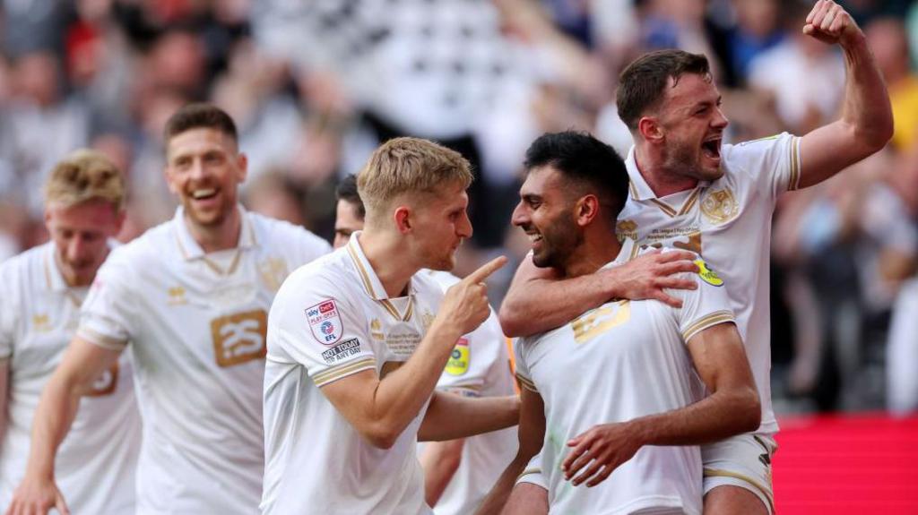 A close up of Nathan Smith celebrating with his team-mates after scoring a goal in the League Two play-off final at Wembley