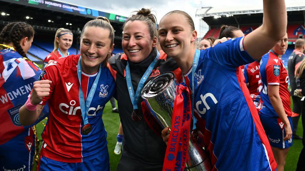 Crystal Palace manager Laura Kaminski with her players and the Women's Championship trophy