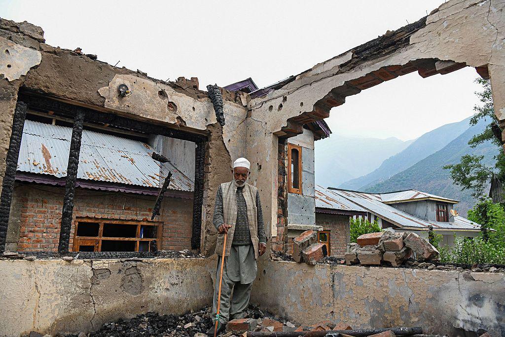 A man stands inside his shell-hit home in Salamabad, Uri, near the Line of Control in Indian-administered Kashmir