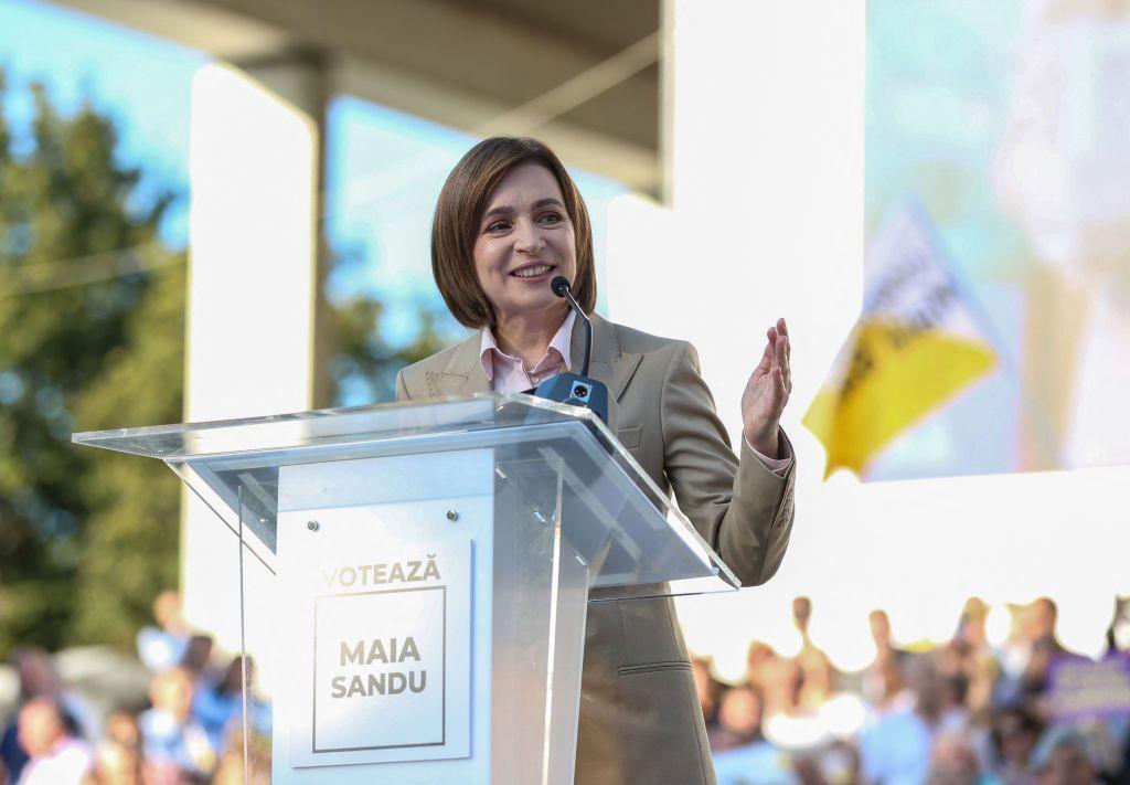 Maia Sandu stands at a lectern, delivering a speech