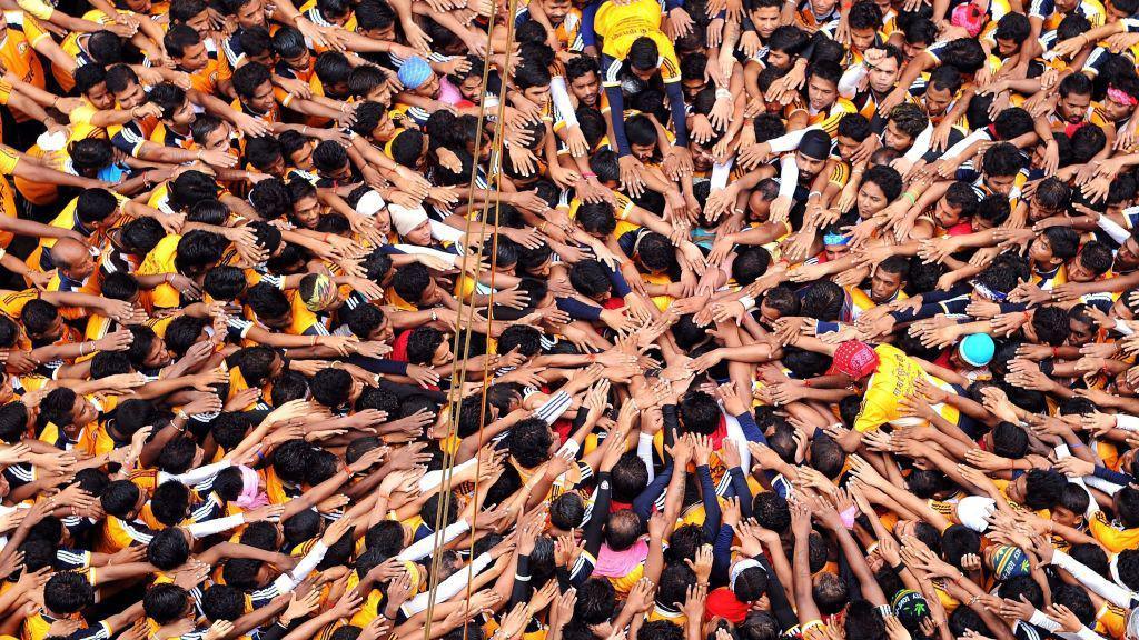 Indian Hindu devotees gesture before attempting to form a human pyramid in a bid to reach and break a dahi-handi (curd-pot) suspended in air during celebrations for the Janmashtami festival, which marks the birth of Hindu god Lord Krishna, in Mumbai on August 18, 2014