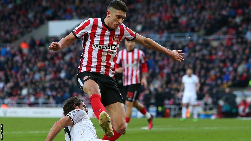 Striker Ross Stewart for Sunderland is tackled by Swansea midfielder Joe Allen