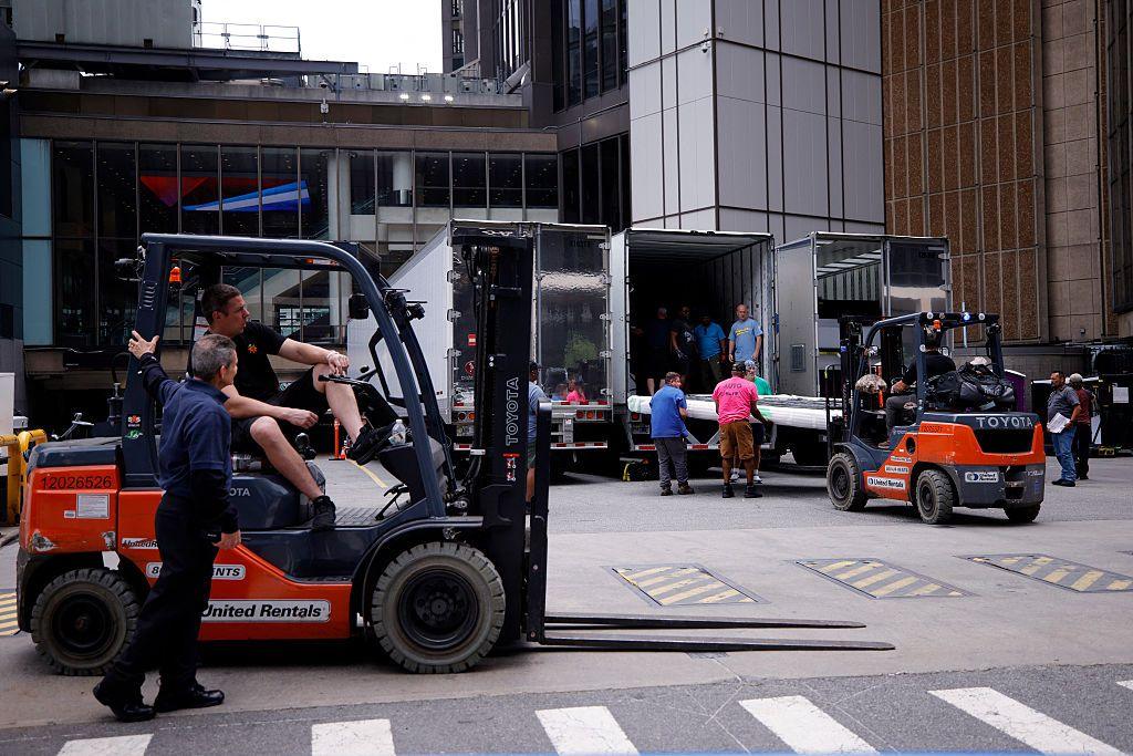 Outside Madison Square Garden, people are seen unpacking multiple lorries parked at the arena. You can see items are being carried on orange forklifts. 