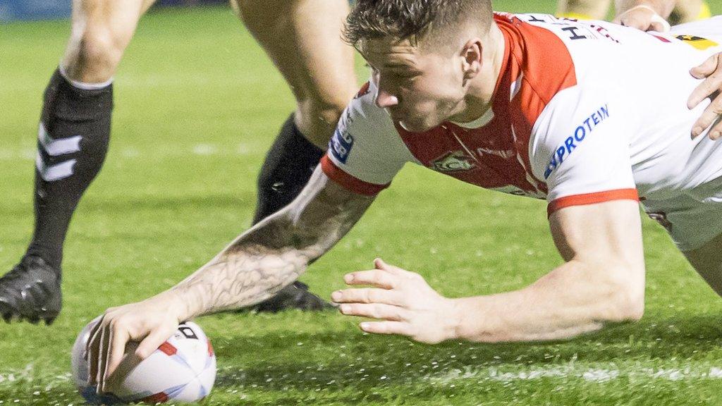 Mark Percival holds off a pair of Warrington tacklers to dive over for his first St Helens try of the night