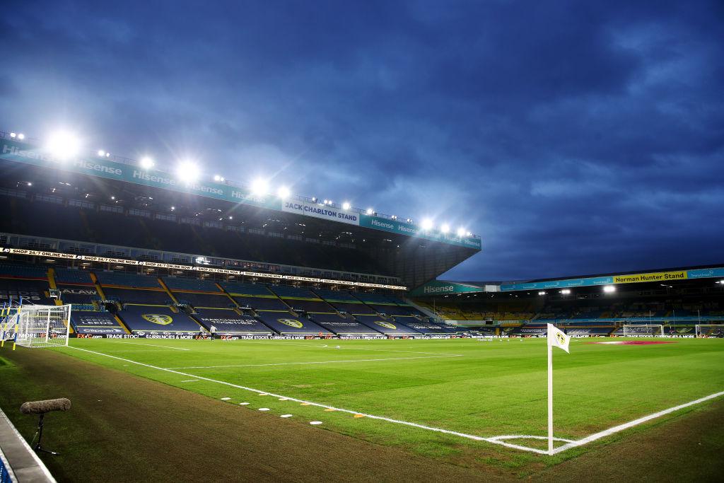 Image of Elland Road stadium with floodlights on and no crowds in the stands