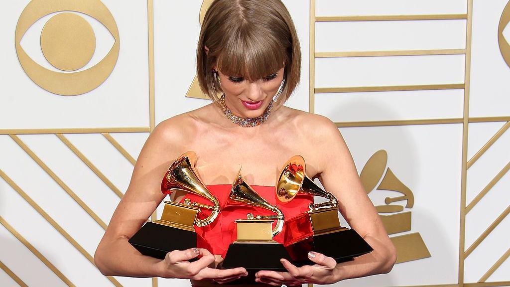Taylor Swift holds her three Grammy Awards.