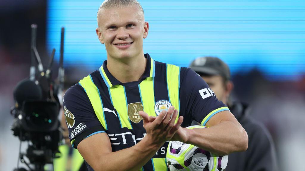 Erling Haaland celebrates with the match ball after scoring a hat-trick for Manchester City against West Ham