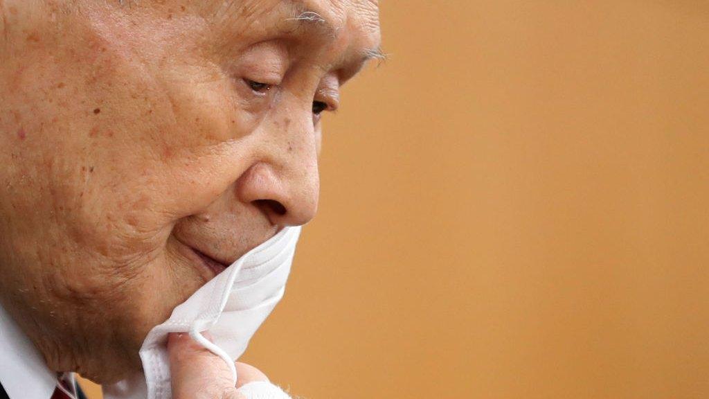 Tokyo Olympics Organizing Committee President Yoshiro Mori removes his face mask before a press conference on 4 February