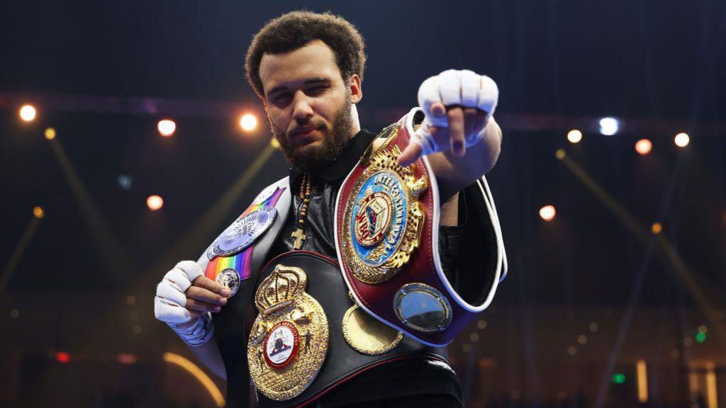 Moses Itauma wears the WBO inter-continental heavyweight, WBA international and Commonwealth silver heavyweight belts and holds out his left hand
