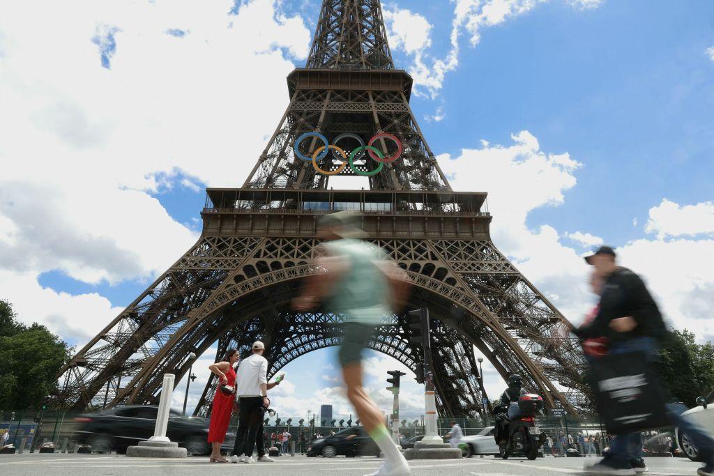 Eiffel Tower with people running in front of it