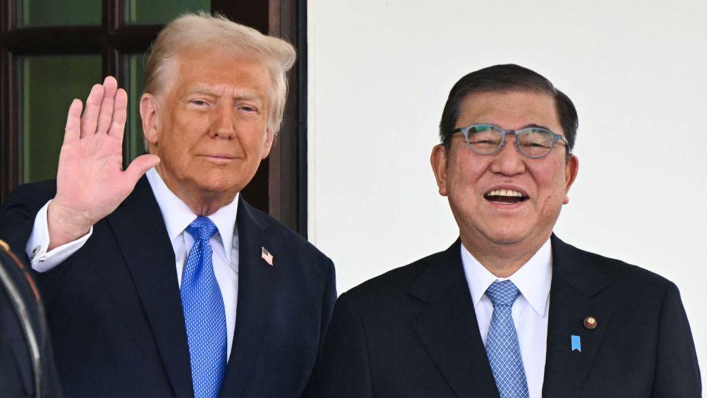 Donald Trump waving next to Japan's Prime Minister Shigeru Ishiba