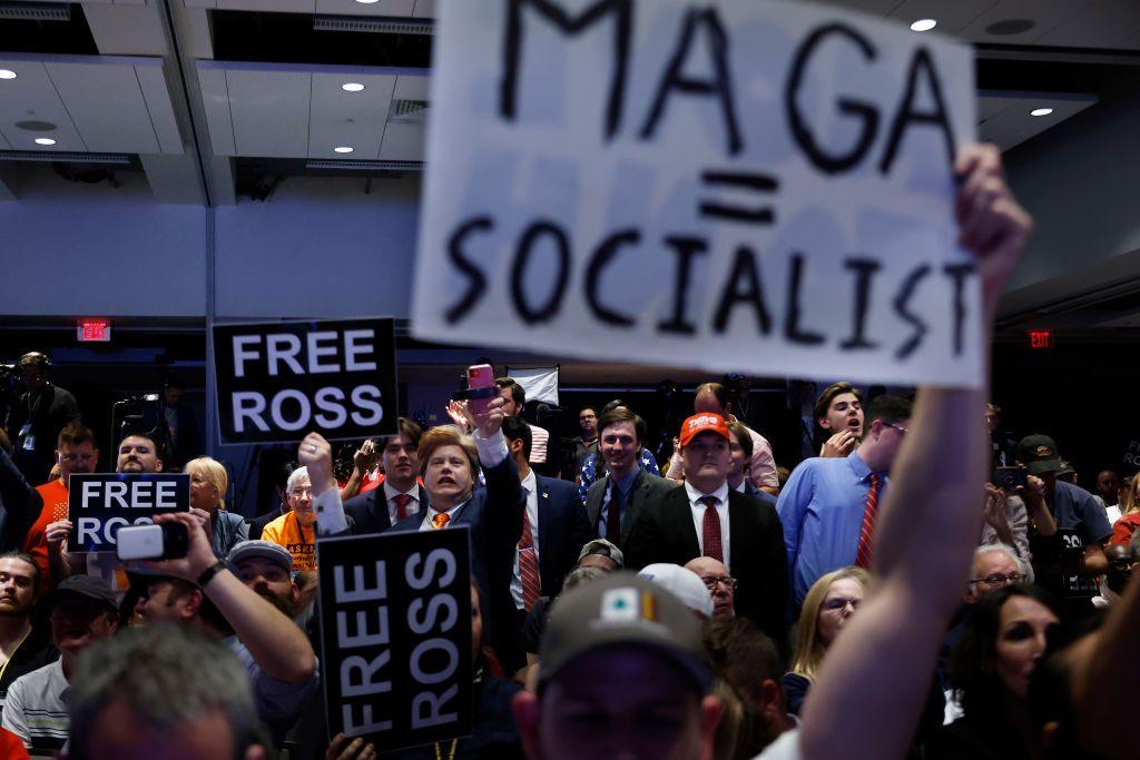 Libertarian delegates hold up signs protesting Donald Trump