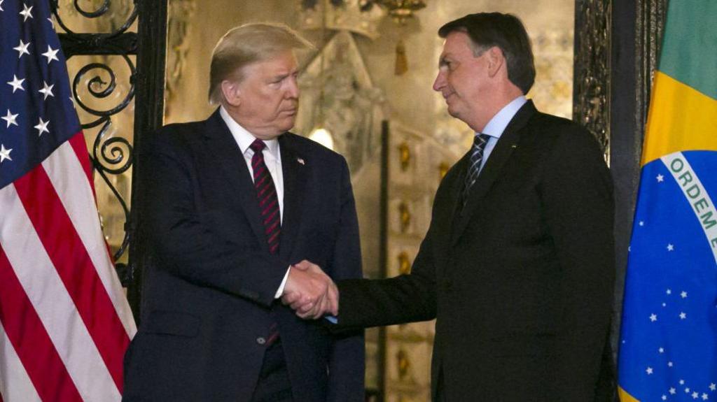 US President Donald Trump shakes hands with Jair Bolsonaro at his Mar-a-Lago resort in Palm Beach, Florida, in March 2020