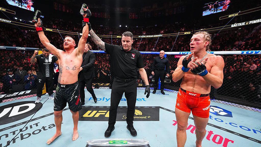 Justin Gaethhe raises his arm in celebration as Paddy Pimblett claps