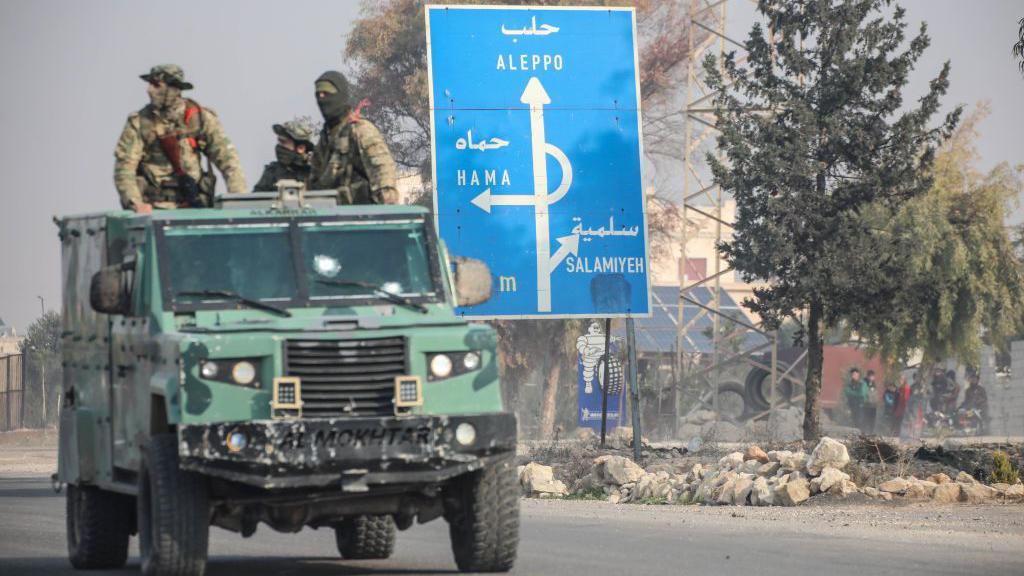 Opposition fighters in the back of a vehicles in Syria