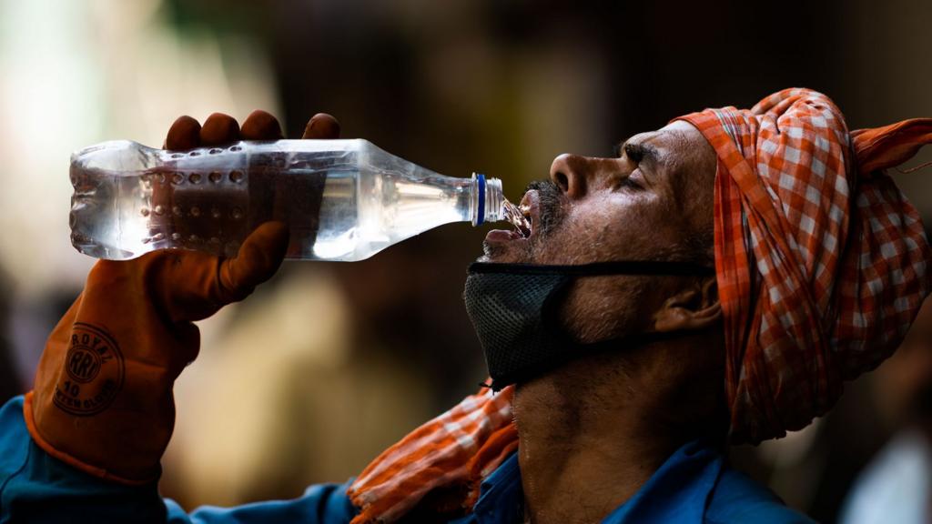 Hot, exhausted man drinking water