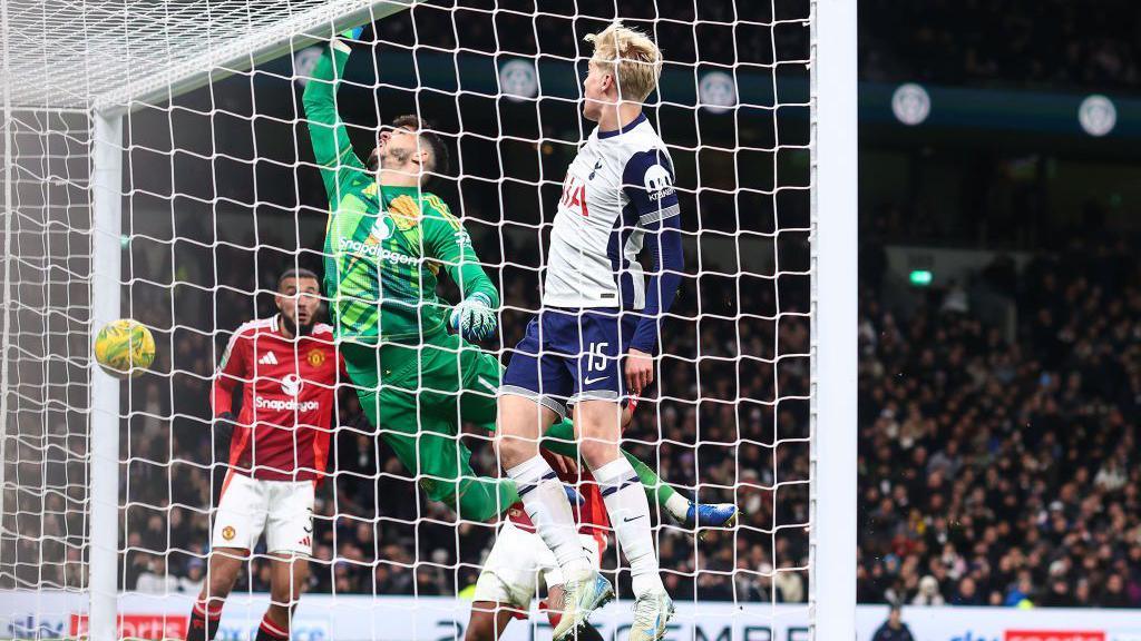 Manchester United goalkeeper Altay Bayindir jumps but misses the ball as Tottenham score a fourth goal