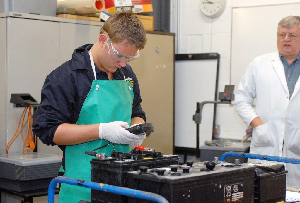 Young man with car batteries