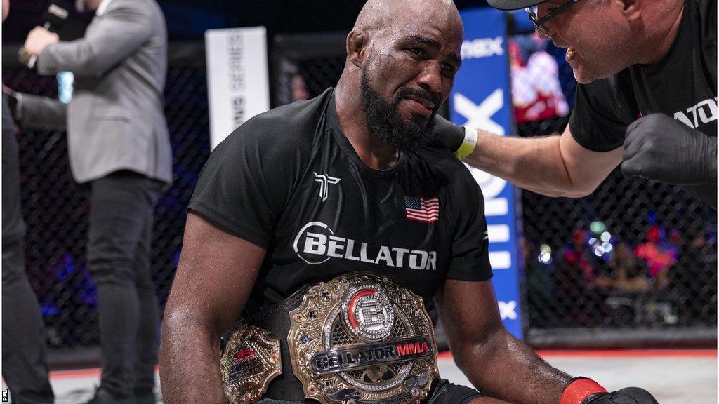 Corey Anderson on his knees emotional with the belt around his waist