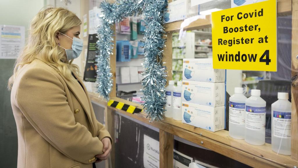 A woman waits in line at the Aneurin Evans community pharmacy on December 8, 2021 in Barry