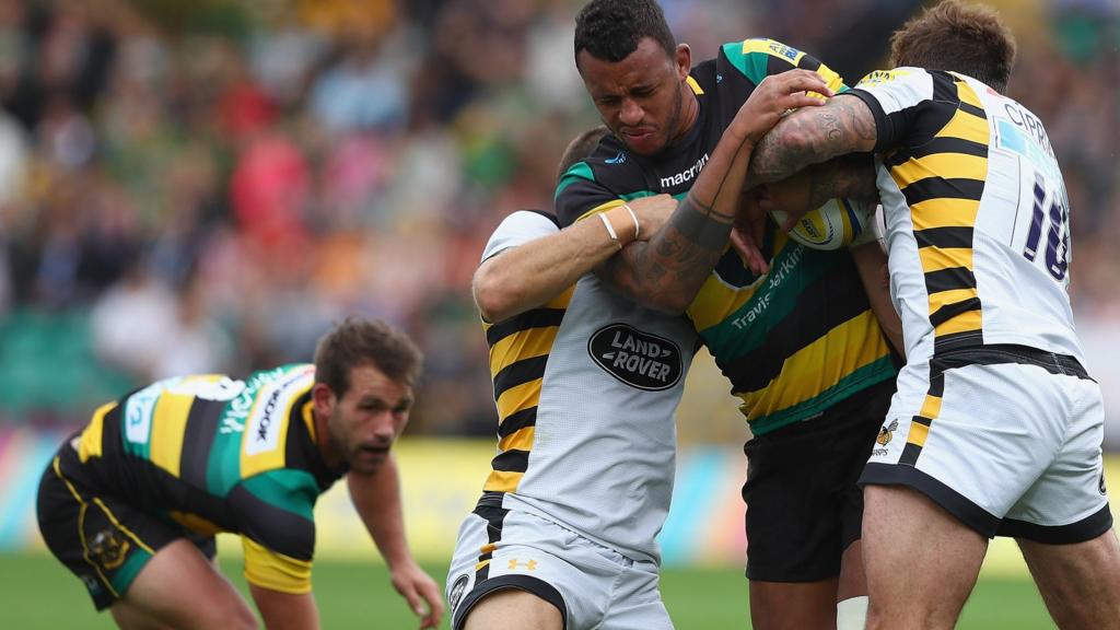 Northampton's Courtney Lawes wrapped up in a tackle by Wasps players