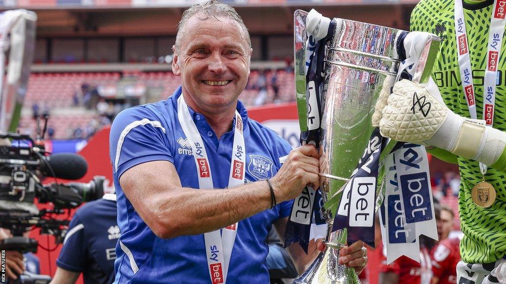 Paul Simpson with the play-off trophy