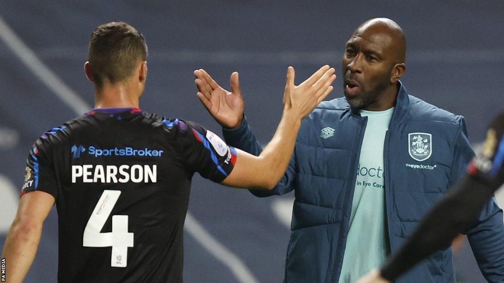 Darren Moore shakes hands with Huddersfield player Matty Pearson