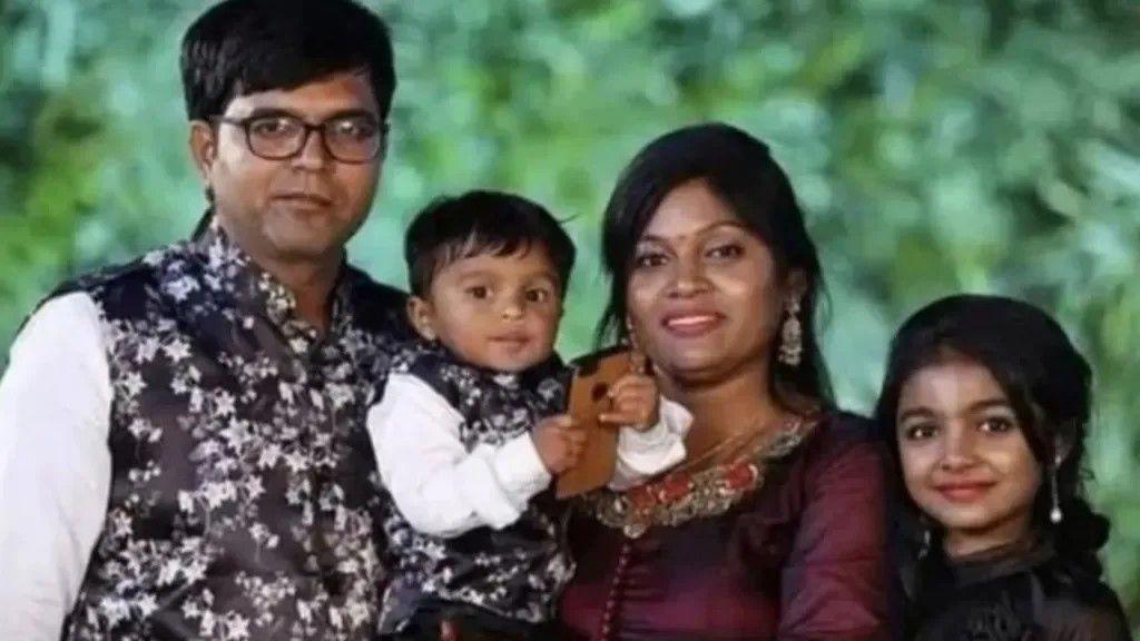 Vaishaliben Patel, her husband Jagdish and their two young children, 11-year-old Vihangi and three-year-old Dharmik wear formal clothing and pose in a family portrait.