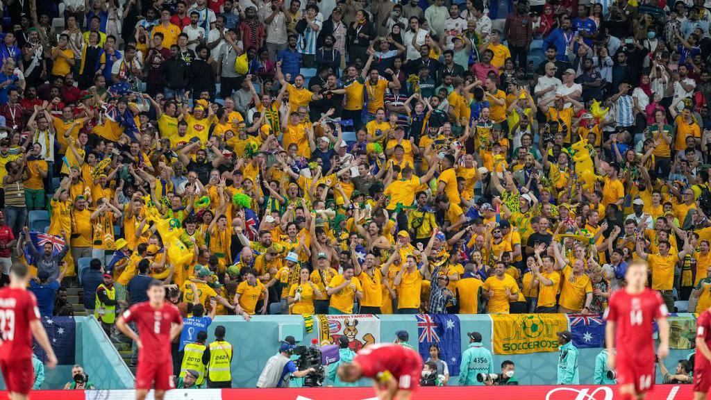 Australia fans celebrate after reaching the last 16 of the 2022 World Cup by beating Denmark in their final group game