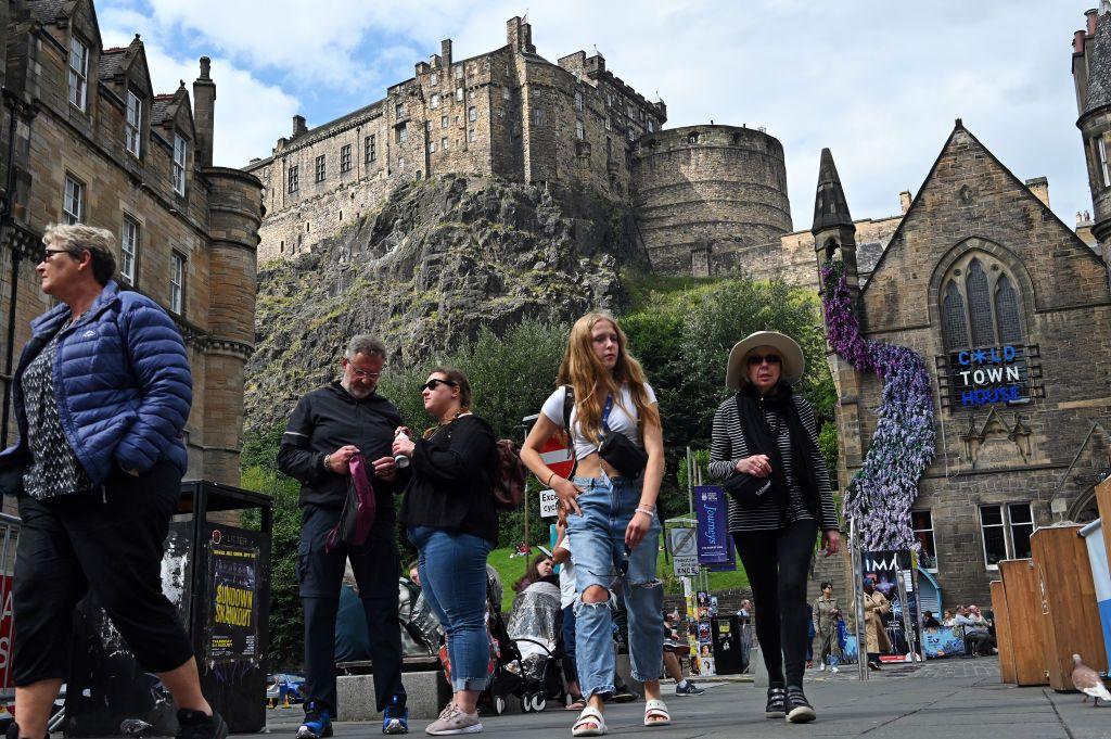 People walking along street below Edinburgh Castle