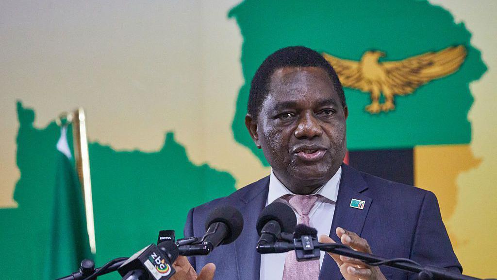 A head and shoulders image of Hakainde Hichilema speaking. A golden eagle from the Zambian flag can be seen behind him.