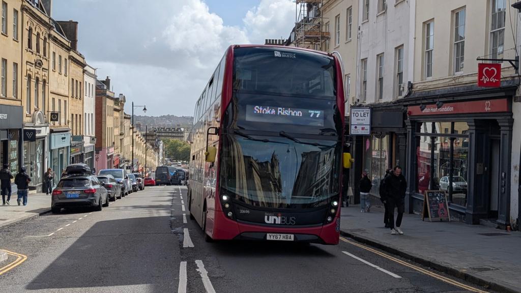 A red bus drives up Park Street in Bristol
