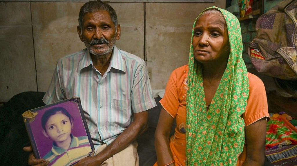 NOIDA, INDIA - JULY 30: the victim of Nithari case, looking at the picture of his daughter Jyoti in his home in Nithari on July 30, 2025 in Noida, India. The Supreme Court has rejected a total of 14 appeals filed against the acquittal of Surendra Koli, accused in the much-talked-about Nithari case of 2006. Moninder Singh Pandher and his domestic help Koli were accused of raping and murdering their neighbours, especially children, in Nithari, Uttar Pradesh. Koli was awarded death penalty by the trial court on September 28, 2010. The high court acquitted Pandher and Koli of the death penalty, holding that the prosecution failed to prove their guilt 'beyond reasonable doubt' and calling it a 'botched' investigation. (Photo by Sunil Ghosh/Hindustan Times via Getty Images)