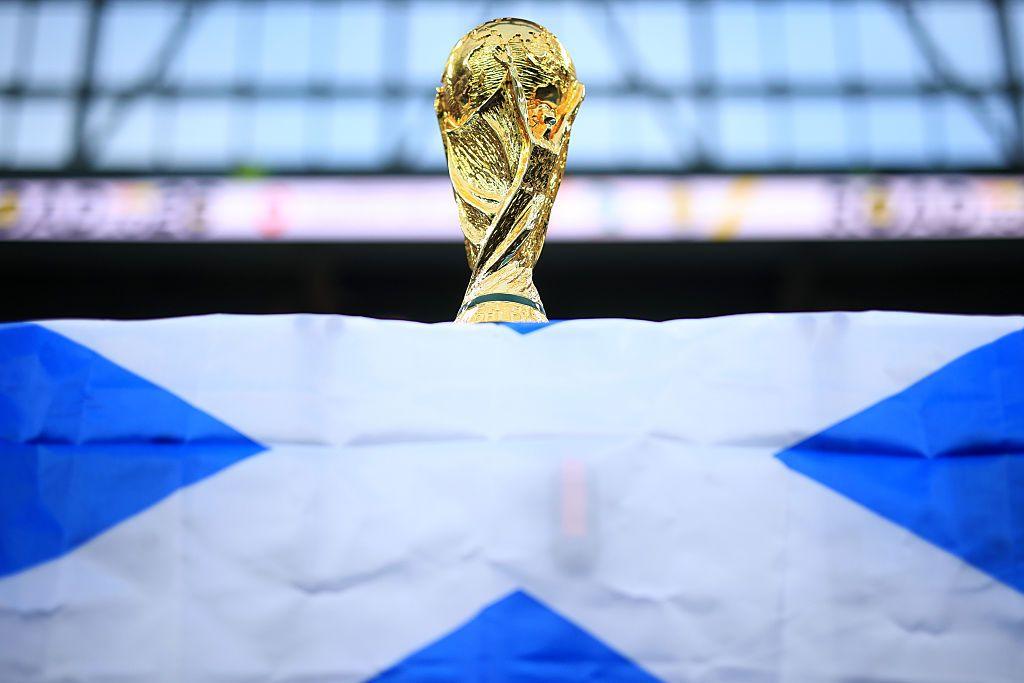 A World Cup trophy is perched on top of a Scotland flag.