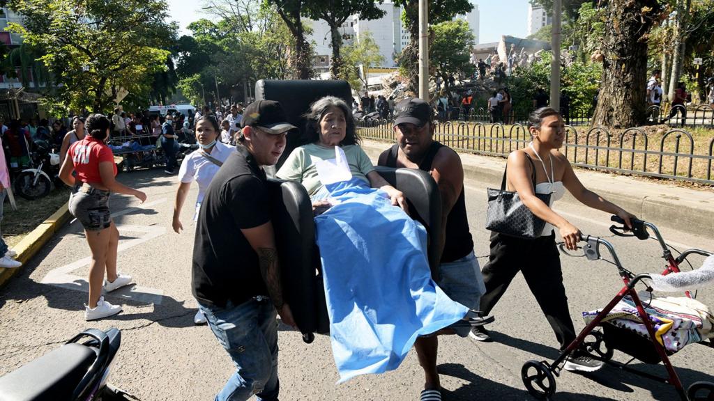 A woman is carried on the street after a powerful earthquake in Colombia