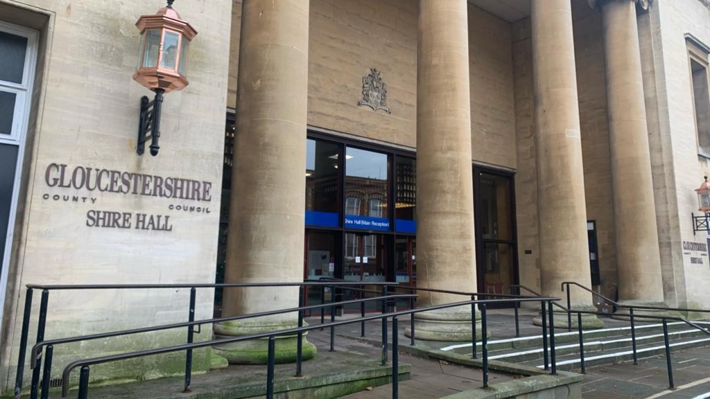 The entrance to Gloucestershire County Council's Shire Hall. It is a large building with steps and four tall stone columns in front of the main doors.