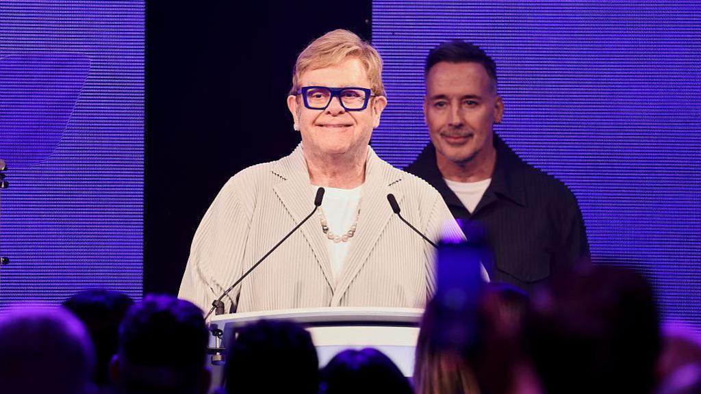 sir Elton John at a podium at the Ivor novellos.