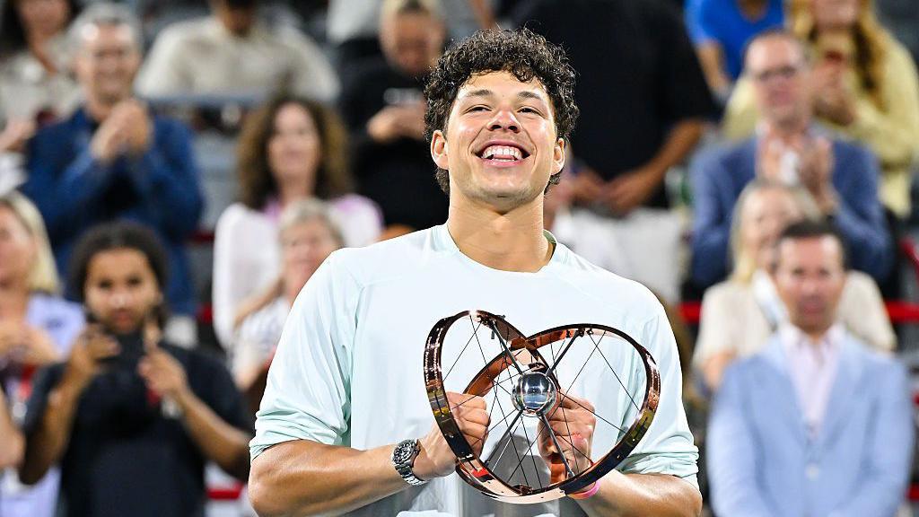 Ben Shelton smiles as he holds the Canadian Open trophy