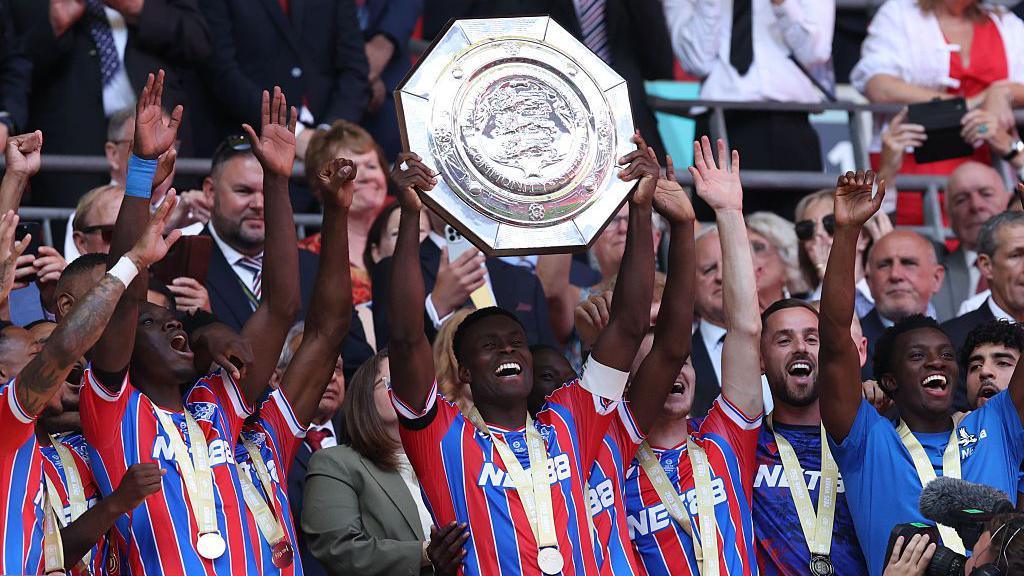 Marc Guehi lifts the Community Shield trophy, surrounded by Crystal Palace team-mates