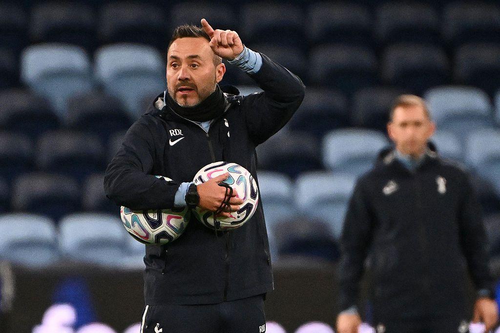 Spurs head coach Roberto De Zerbi delivers instructions during training with two balls tucked under his arm