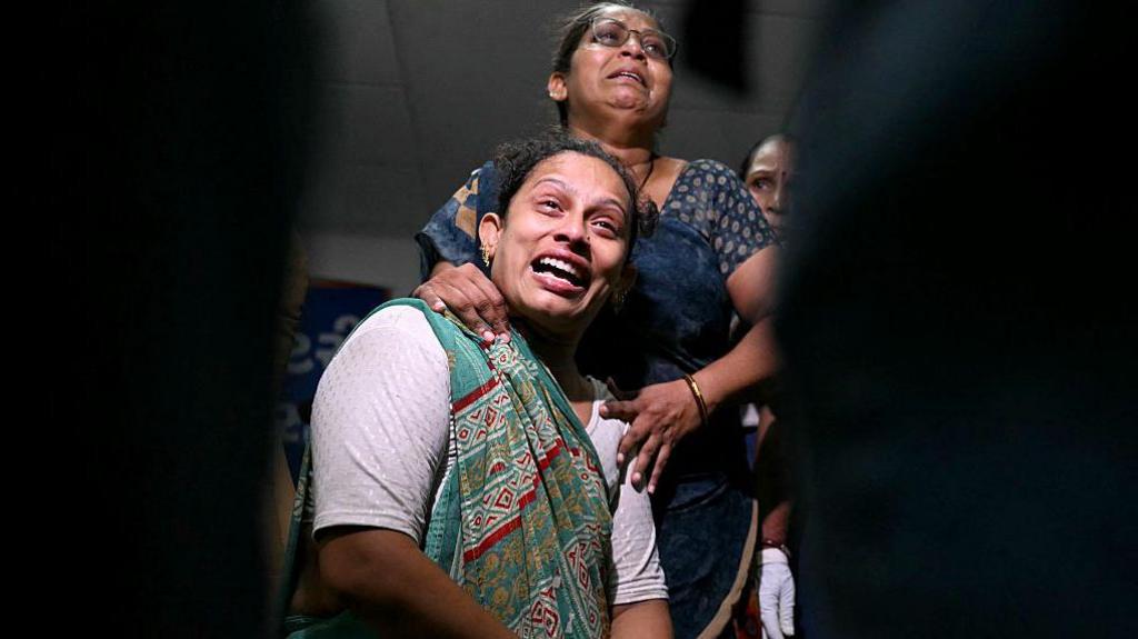 Relatives mourn as they await DNA sample tests, for their loved ones to be identified, at an emergency centre in Ahmedabad on June 13, 2025, a day after Air India flight 171 crashed in a residential area. Rescue teams with sniffer dogs combed the crash site on June 13 of a London-bound passenger jet which ploughed into a residential area of India's Ahmedabad city, killing at least 265 people on board and on the ground. (Photo by Punit PARANJPE / AFP) (Photo by PUNIT PARANJPE/AFP via Getty Images)