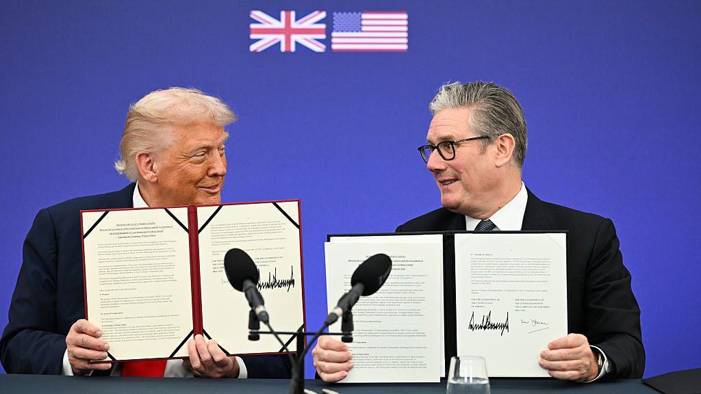 US President Donald Trump, left, and UK Prime Minister Sir Keir Starmer sign the Tech Prosperity Deal during a business reception at Chequers, near Aylesbury, on Thursday, 18 September, 2025. Each man holds a copy of the which bears both their signatures. 