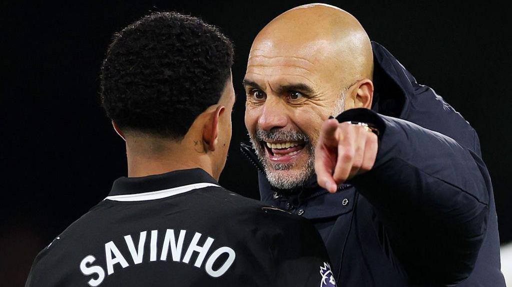 Pep Guardiola points as he talks to Savinho during Manchester City's win at Fulham