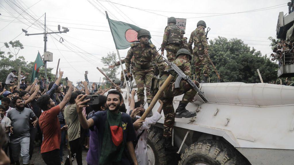 Protesters seen celebrating with soldiers