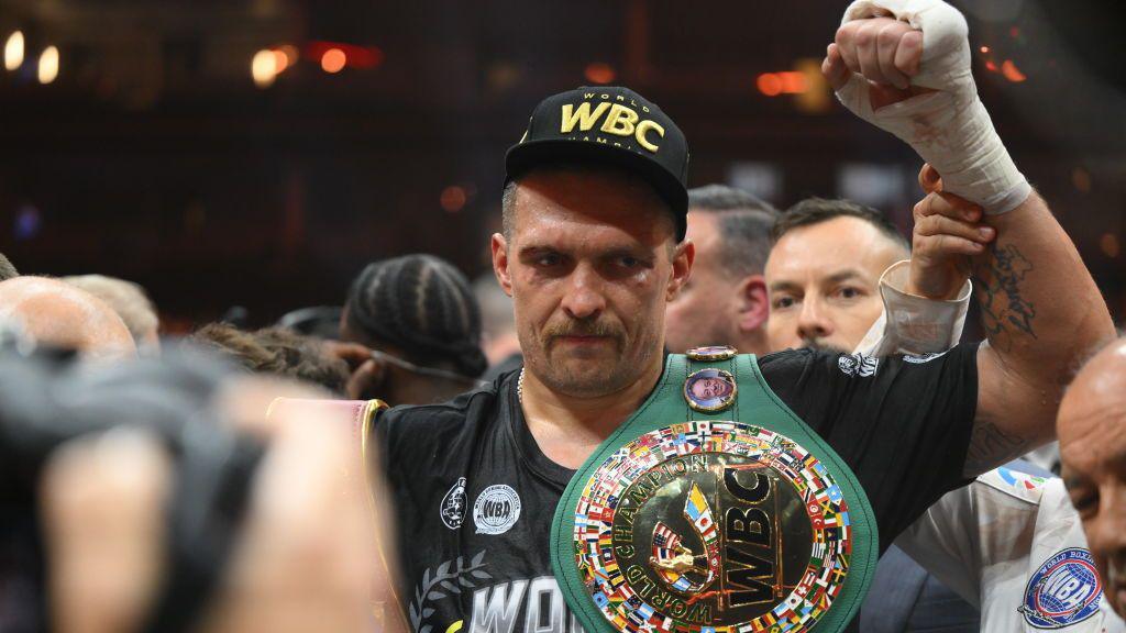 Oleksandr Usyk celebrates with the belts after beating Tyson Fury