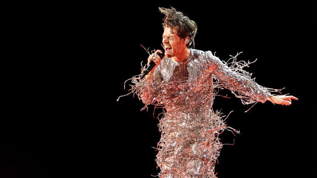 Harry Styles performs on stage.