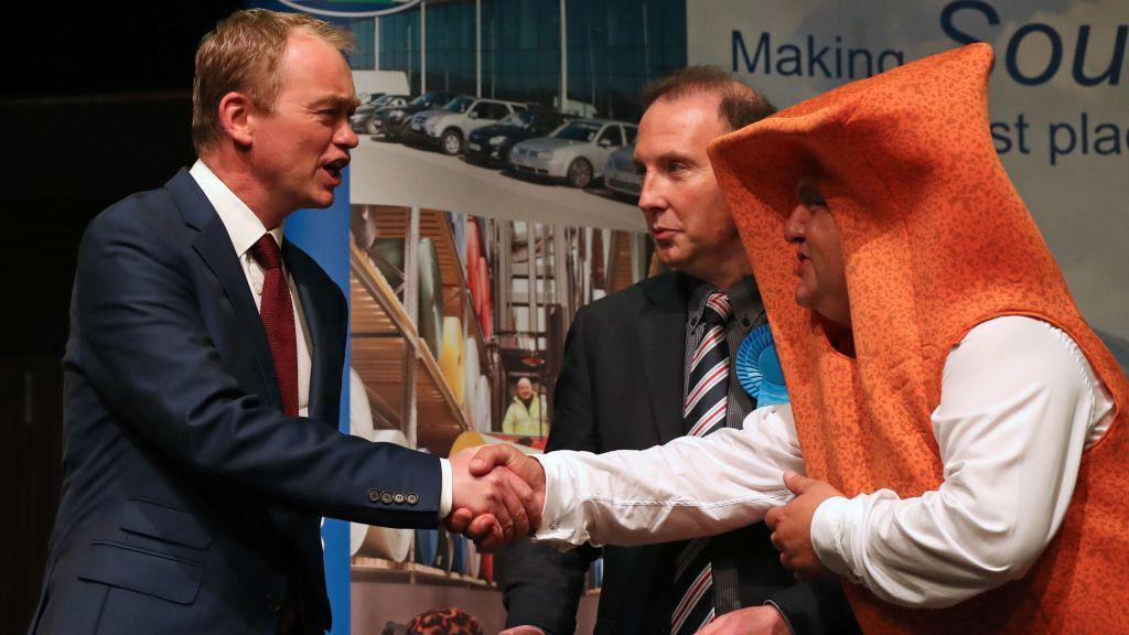 Tim Farron shakes hands with Mr Fishfinger at the Westmorland and Lonsdale count on June 9, 2017