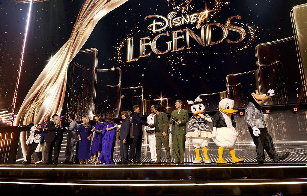 People stand on a stage under the words Disney Legends.