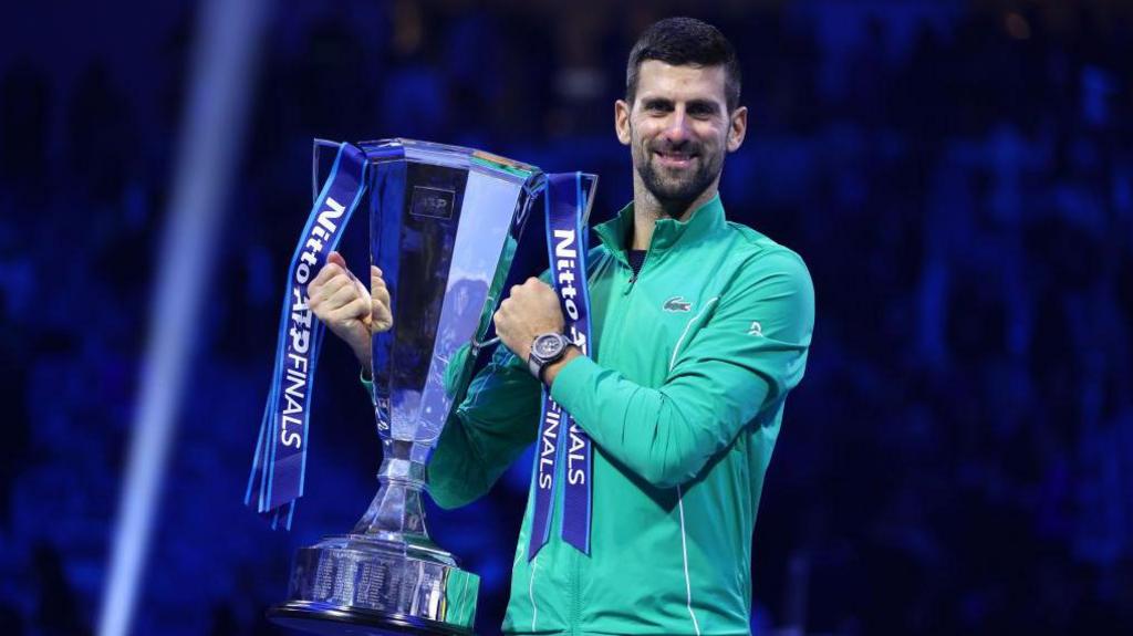Djokovic holds up the ATP Tour Finals trophy in 2023